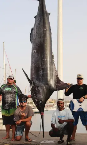  ??  ?? Capt. Olaf Grimkowski, Christiaan Kruger, Elton Fortes Lopes and Bates with the 2020 Blue Marlin World Cup winner, weighing 964 pounds.