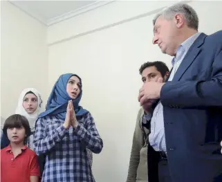  ??  ?? Syrian refugee Samar Barri, who is staying with her family at a house in Athens while awaiting relocation to another European country, speaks with United Nations High Commission­er for Refugees Filippo Grandi yesterday.