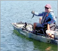  ?? Keith Bryant/The Weekly Vista ?? Jason Adams with Ozark Mountain Trading Company and Fish it Forward shows off the last bass he caught in Lake Windsor during Saturday's Kayak Bass Fishing Trail tournament he helped organize.