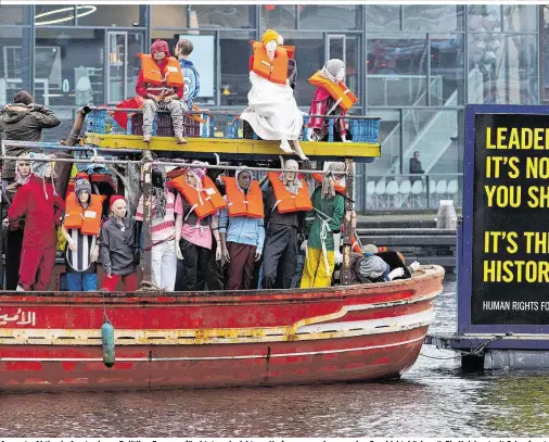  ??  ?? Amnesty-Aktion in Amsterdam: „Politiker Europas, fürchtet euch nicht vor Umfragen, sondern vor den Geschichts­büchern“. Ein Holzboot mit Schaufenst­e