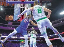  ?? MATT SLOCUM AP ?? 76ers’ Joel Embiid (left), who had 27 points and 10 rebounds, stares at Celtics’ Kristaps Porzingis after a dunk during the first half Wednesday in Philadelph­ia.