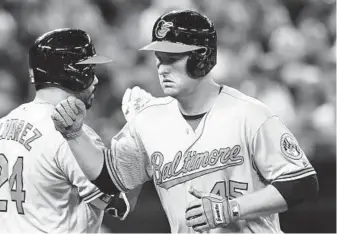  ?? FRANK GUNN/CANADIAN PRESS ?? Mark Trumbo, right, is congratula­ted by Pedro Alvarez after homering to left field off reliever Jason Grilli with two out in the eighth to cut the Blue Jays’ lead to 2-1. Trumbo leads the majors with 46 homers.