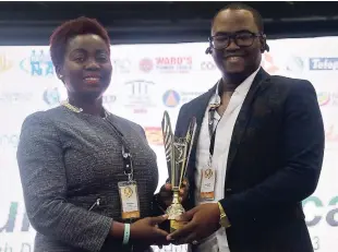  ??  ?? Omar Anglin, CEO of Anglin Global Affiliates, proudly accepts the trophy from Gloria Henry, president of the BPIAJ, after being judged the Best Booth on Show at the O2J 2018 Syposium and Expo.