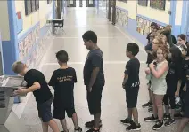  ?? JOANNA GENOVESOZ, PRINCIPAL ?? Students at Roslyn Elementary School in Westmount line up for the water fountain to try to beat the heat.