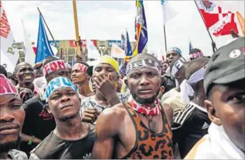  ??  ?? Precarious peace: The United Nations maintains a military presence (left) in the eastern DRC; demonstrat­ors call for elections to end.