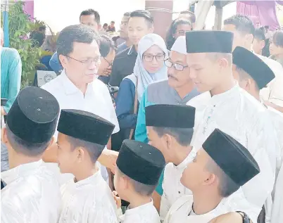  ??  ?? KANAK-kanak ini tidak melepaskan peluang bersalam dengan Shafie semasa menghadiri majlis rumah terbuka di kediaman Dr Azman.