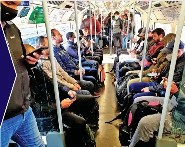  ??  ?? Back to work: Commuters on London’s Tube struggle to stay 2m apart yesterday