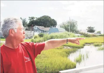  ??  ?? Rick Tanasi points to where he says water flowing under the Old Saybrook bridge has eroded marshland over the last decade.