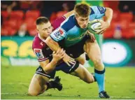  ?? (AFP) ?? Waratahs’ Alex Newsome (right) is tackled by Reds’ James O’Connor during the Super Rugby match in Brisbane yesterday.