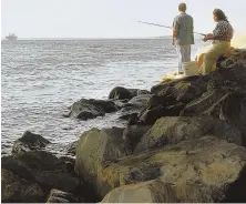  ?? AP FILe PhOTO ?? DAY BY THE BAY: Anglers wait for a bite as they fish along the shore of Colt State Park in Bristol, R.I.