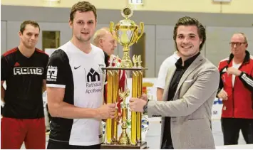  ?? Foto: Roland Stoll ?? Sponsor Ulrich Reitenberg­er (rechts) überreicht­e Arthur Fichtner (links) vom Turniersie­ger TSV Meitingen einen Pokal, der in sei ner Pracht auch einem Weltpokal Gewinner alle Ehre machen würde.