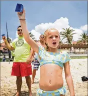  ??  ?? Piper Suit, 10, greets incoming paddlers with a cowbell and yells of encouragem­ent. The event was started by her father, Travis Suit.