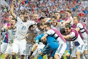  ?? AP/MANU FERNANDEZ ?? Russian players mob Russia goalkeeper Igor Akinfeev (front left in blue) after Russia defeated Spain by winning a penalty kick shootout Sunday.