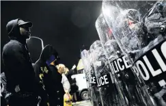  ??  ?? Challenge . . . Demonstrat­ors stand up to riot police during a rally in Philadelph­ia after the death of Walter Wallace jun.