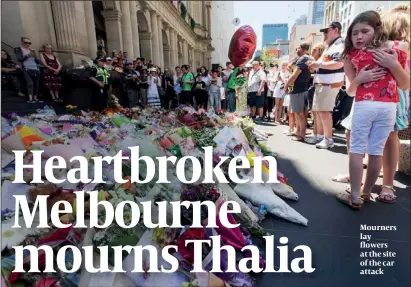  ?? PHOTO: GETTY IMAGES ?? Mourners lay flowers at the site of the car attack