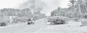  ??  ?? Yemeni pro-government forces backed by the Saudi-led military alliance advance during their fight against Huthi rebels in the area of Hodeida’s airport. — AFP photo