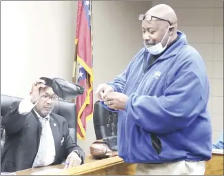  ?? Brodie Johnson • Times-Herald ?? Kendall Owens, right, a candidate for a St. Francis County Quorum Court seat, draws for a position on the May Preferenti­al Primary Ballot from a hat held by SFC Election Commission­er Frederick Freeman. Owens is running as a Democrat for the JP District 10 seat against Victor Stegall and Arthor Witherspoo­n, who also filed as Democrats. Incumbent Leodis Williams did not file for reelection.