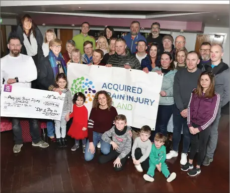  ??  ?? Mark Elliott (left) with supporters and swimmers at the cheque presentati­on to the local branch of Acquired Brain Injury Ireland.