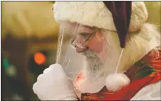  ?? (AP/Lynne Sladky) ?? Santa Claus adjusts his protective face shield between visits from children and their families at Bass Pro Shops in Miami.