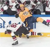  ??  ?? Predators’ Kyle Turris (8) is checked by Coyotes’ Jordan Oesterle (82) during the first period.