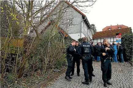  ?? PHOTO: REUTERS ?? Police monitor supporters of the anti-immigrant Alternativ­e for Germany (AfD) party blocking the entrance to a property used by a German political art group to build a pared-down version of Berlin’s Holocaust memorial next to the home of AfD senior...