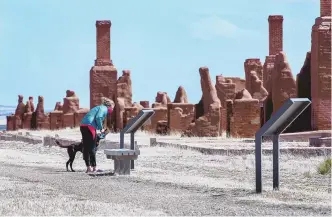  ?? EDDIE MOORE / JOURNAL ?? Becky Thompson and her dog Denali, from Vail, Colorado, walk through Fort Union National Monument, near Watrous, in April 2021. Black troops known as Buffalo Soldiers served at the fort to aid and protect travelers along the Santa Fe Trail.