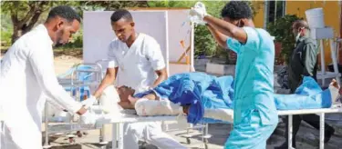  ?? Reuters ?? ↑
Paramedics push an injured soldier on a stretcher in Darkenley district of Mogadishu on Wednesday.