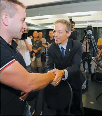  ?? PHOTO PASCAL HUOT ?? Adrien Pouliot (à droite) est vite passé à l’attaque contre la CAQ, hier, au lancement de sa campagne à Québec. On le voit serrer la main d’un partisan lors de l’événement qui s’est tenu dans un hôtel du secteur Charlesbou­rg.