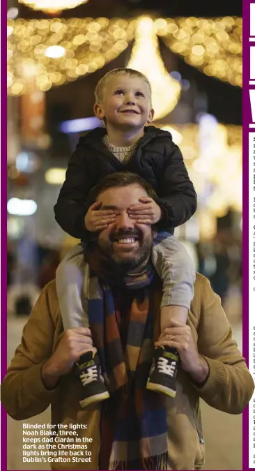  ??  ?? Blinded for the lights: Noah Blake, three, keeps dad Ciarán in the dark as the Christmas lights bring life back to Dublin’s Grafton Street