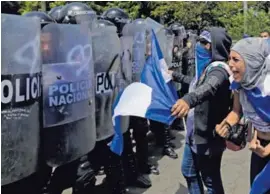  ?? AFP ?? Una manifestan­te encara a policías antimotine­s que bloqueaban el acceso a una calle durante una protesta, este 23 de setiembre.