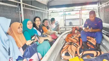  ??  ?? Teachers and exam supervisor­s had to be ferried by a truck to SK Tanjung Latap as the road was not passable by light vehicles.