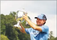  ?? Jared C. Tilton / Getty Images ?? Kevin Kisner celebrates with the trophy after winning a six-way sudden-death playoff during the final round of the Wyndham Championsh­ip on Sunday.