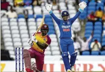  ?? ?? India’s wicket keeper, Ishan Kishan (right), celebrates the dismissal of the West Indies’ Kyle Mayers during a T20 match in Tarouba, Trinidad and Tobago. India lost by four runs. India is about to build the world’s largest cricket stadium (132,000 seats) in Ahmedabad.