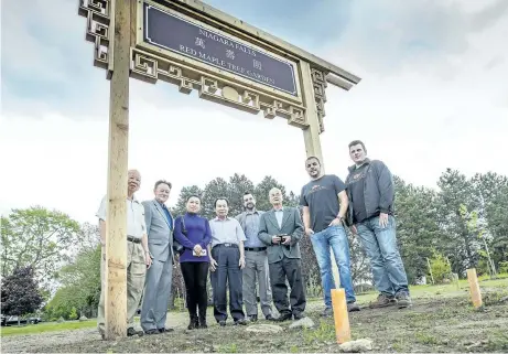  ?? BOB TYMCZYSZYN/POSTMEDIA NETWORK ?? Members of the Chinese Cultural Associatio­n of Niagara, together with staff from Yardmaster­s Niagara, Niagara Falls Coun. Kim Craitor and Mark Richardson, the city's manager of cemetery services, check out the new gateway arch that marks the entrance to the new Chinese community section of Fairview Cemetery in Niagara Falls.