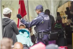  ??  ?? File photo shows a Royal Canadian Mounted Police officer talking to migrants after they crossed the Canada/US border illegally near Hemmingfor­d, Quebec. — AFP photo