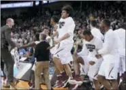  ?? THE ASSOCIATED PRESS FILE ?? Saint Joseph’s players and coaches celebrate after winning a first-round game in the NCAA Tournament against Cincinnati in 2016. It was the Hawks’ and now-former head coach Phil Martelli’s last NCAA victory.