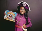  ??  ?? Author and Atlanta Public School third grader Selah Thompson with her first book, “Penelope the Pirate Princess.”