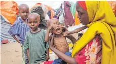  ?? FOTO: FARAH ABDI WARSAMEH/AP/DPA ?? In einem Lager für Vertrieben­e am Stadtrand von Mogadischu hält eine Mutter, die aus einer von Dürre heimgesuch­ten Region geflohen ist, ihre unterernäh­rte einjährige Tochter.