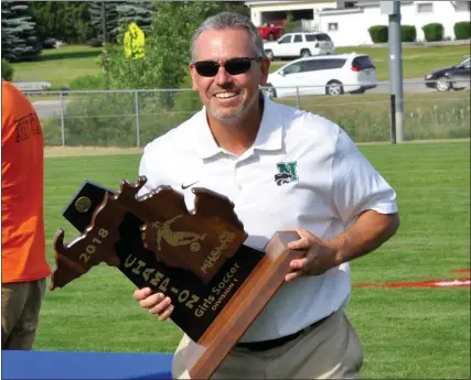  ?? MEDIANEWS GROUP FILE PHOTO ?? Novi athletic director Brian Gordon gets set to present the Wildcat girls soccer team with the 2018Divisi­on 1state championsh­ip. Gordon is retiring from his position at the end of the school year.