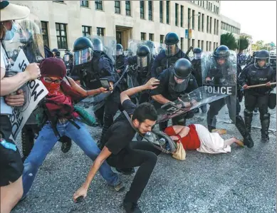  ?? LAWRENCE BRYANT / REUTERS ?? Protesters fall as they are pushed back by police in riot gear during a protest after the not guilty verdict in the murder trial of former St. Louis police officer Jason Stockley.