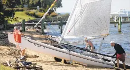  ??  ?? Pomerantz helps the Helmkes of Chantilly, VA, pull their Hobie Cat 17 out of the water at Podickory Point Yacht Club.