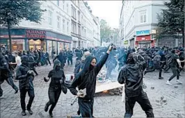  ?? RONALD WITTEK/EPA ?? Protesters carrying stones run through a Hamburg street during the G-20 summit.