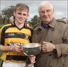  ??  ?? Rathnure captain Dylan Hogan with Brendan Furlong of People Newspapers and the Nolan-Fogarty Memorial Cup.