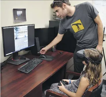  ?? UNIVERSITY OF GUELPH ?? Andrew Vierich, a University of Guelph software developer, looks on as Ruby Corbett learns how to safely cross streets using a virtual reality program.