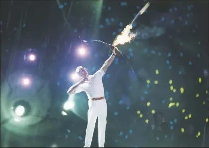  ??  ?? An arrow carrying the Olympic flame leaves the bow of Antonio Rebollo to light the Olympic Torch and open the XXV Olympic in Barcelona in 1992. (File Photo/AP/Dominique Mollard)