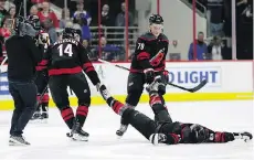  ?? GERRY BROOME/AP ?? Hurricanes players drag Jordan Martinook from the ice after he was “knocked out” by retired boxer Evander Holyfield while celebratin­g a win. Carolina has won eight of its last 10 games.