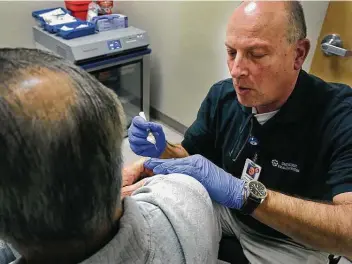  ?? Staff file photo ?? A clinical pharmacist administer­s the shingles vaccine to a 61-year-old at a University Health System clinic in 2018. The shingles vaccine works well, but it’s not 100 percent effective.