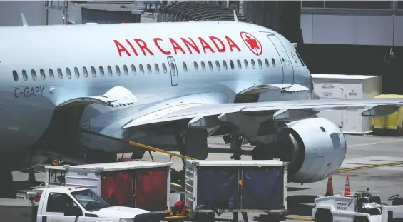  ?? JUSTIN SULLIVAN/ GETTY IMAGES ?? An Air Canada plane is parked at the San Francisco airport Tuesday. Air Canada and WestJet conduct pre-boarding temperatur­e checks and require masks as COVID precaution­s, though they have resumed selling adjacent seats . Dr. Theresa Tam, Canada’s top public health officer, says people should assess their own risk levels and need to fly.