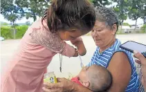  ??  ?? ALEGRÍA. Marina da una cucharada de gerber a su prima Génesis Marisol, de cinco meses de nacida.