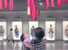  ?? ZOU XIAOQI 2019 ?? Zou Xiaoqi, a single mother turned activist, holds her son at a museum in Shanghai. Zou and other single mothers are publicly campaignin­g for maternity benefits.
